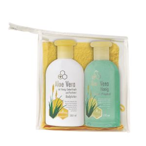 Aloe Vera Bodylotion und Duschgel mit einem gelben Waschlappen in einem durchsichtigen Kulturbeutel